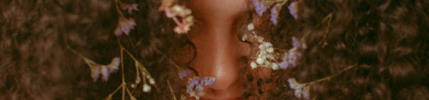 Gesicht mit Haaren mit eingeflochtenen Blumen